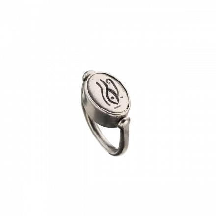 טבעת כסף דו צידית, בצדה האחד משובצת אבן טורקיז ובצדה השני, חריטת עיטור "העין של רע"